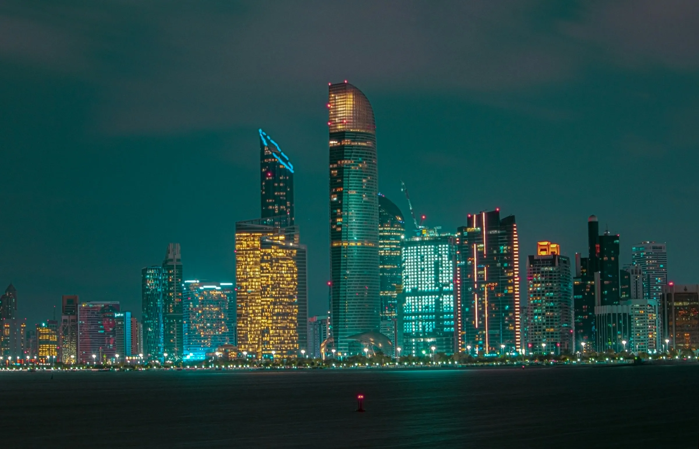Abu Dhabi city skyline lit up at night across the water