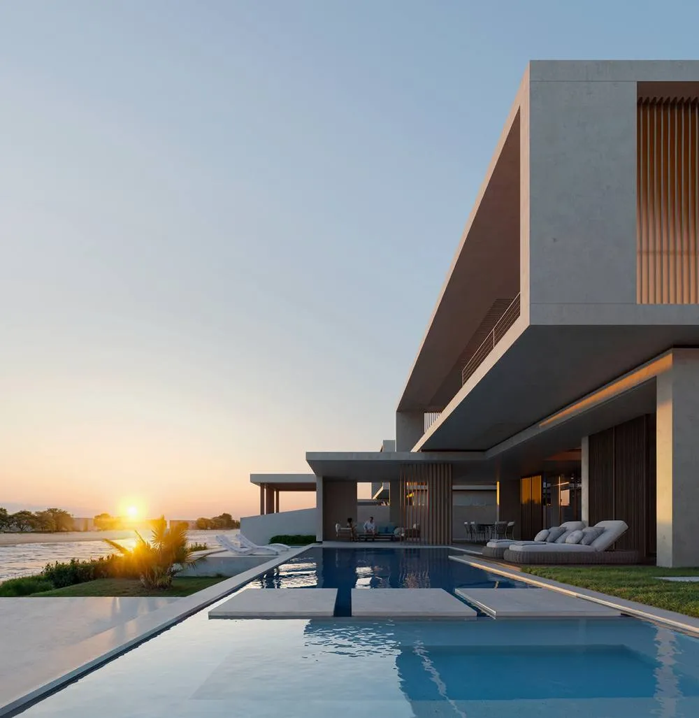 Contemporary villa with a pool facing the water at sunset